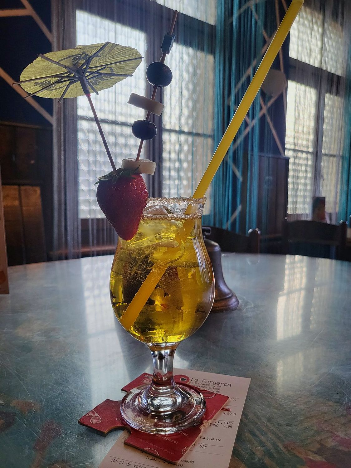 Cocktail maison décoré d'un parasol et d'une brochette de fruits