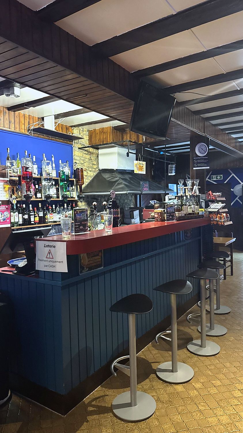 Le comptoir rouge du Bar Le Forgeron, en pierres et bois